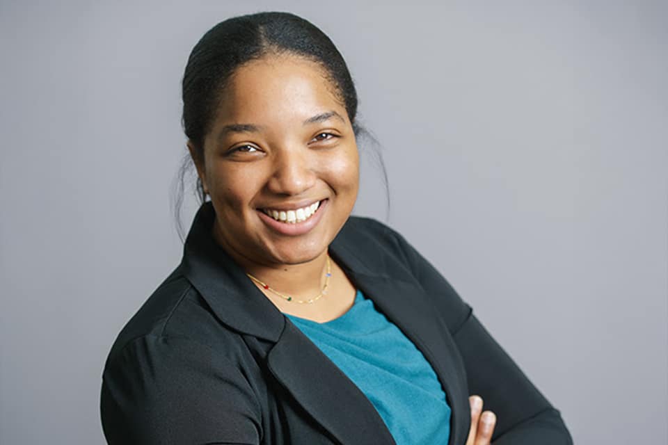 image of Haniska Prinston wearing a teal shirt and a black blazer - Construction team