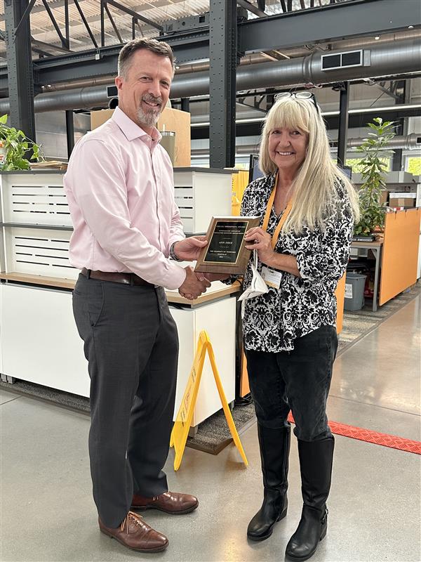 Associate Vice Chancellor Mike Brady hands Ann Free the 2024 Chuck Thompson Award for the Service/Clerical category at the Facilities Services Complex