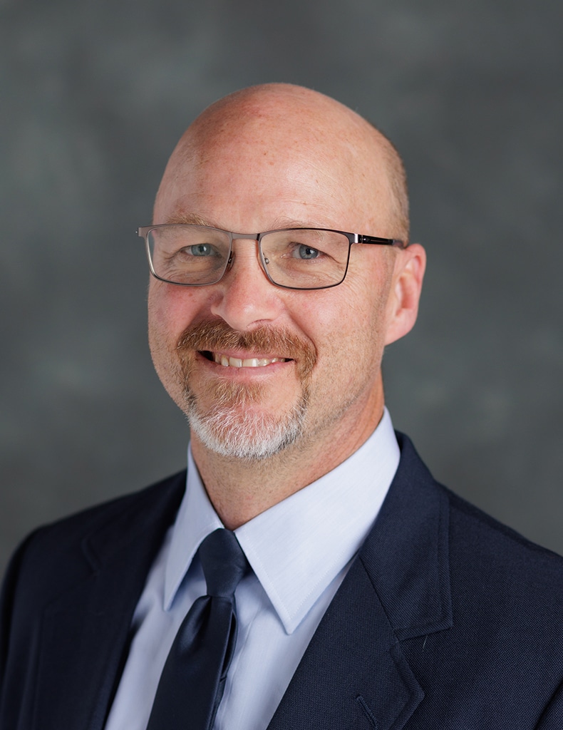 image of Assistant Vice Chancellor Matt Motsko wearing a light blue shirt with a dark blue tie and jacket