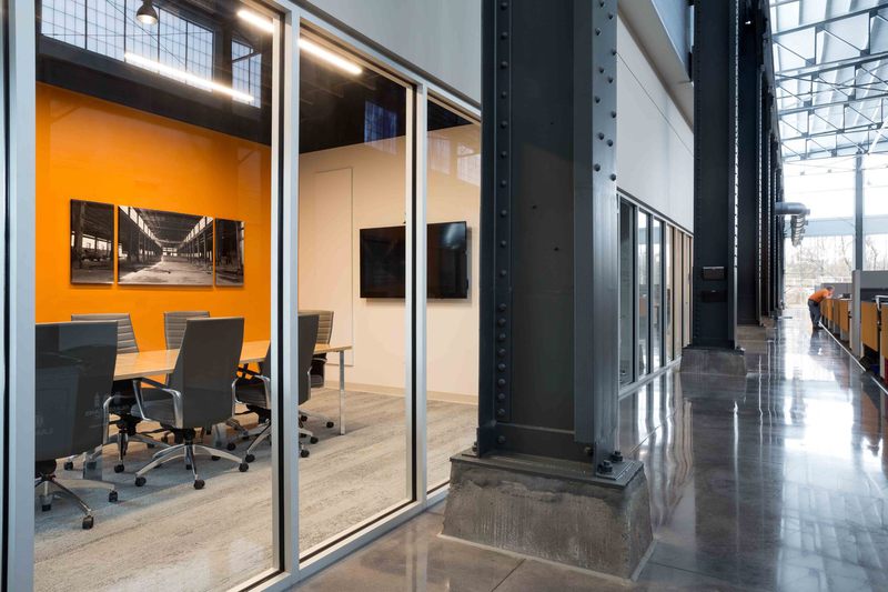 Facilities Services conference room with rolling chairs and historic photographs of the facility