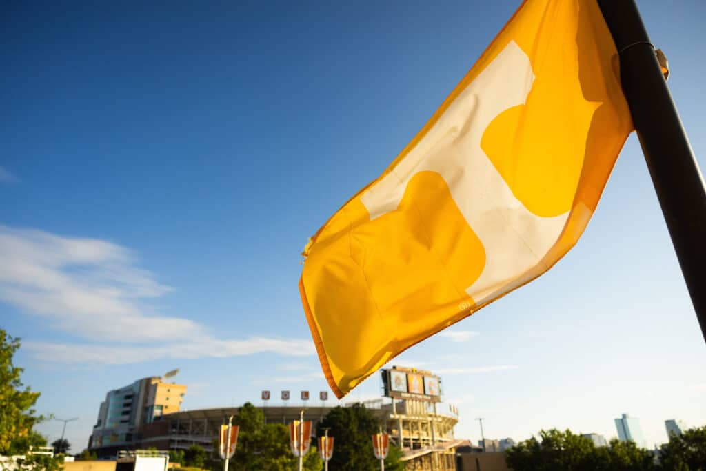 A Power T flag flies in the air with blue skies and Neyland stadium in the background