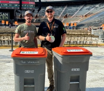 Two Sustainability team members smile and offer a thumbs up while preparing for the Morgan Wallen concerts at Neyland Stadium in 2024