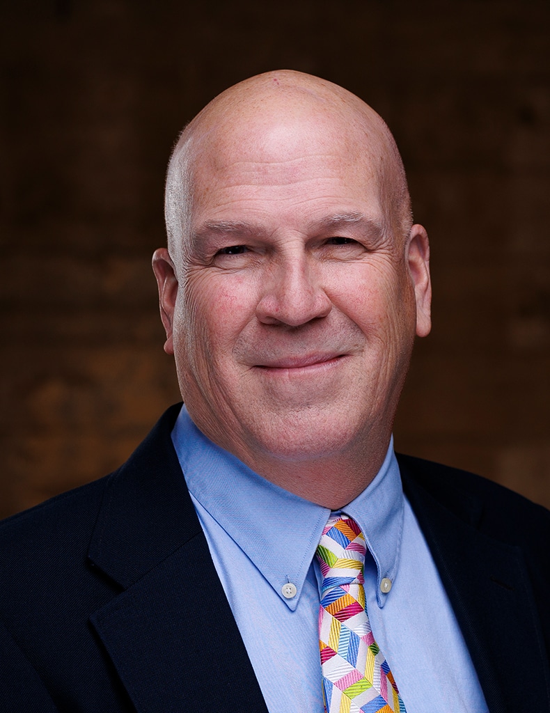 image of Ted Murphy wearing a light blue shirt, colorful tie, and dark blue jacket